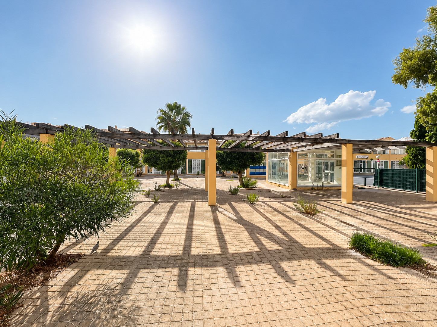 Zona comercial con locales y pérgolas exteriores